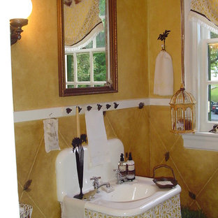 Ispirazione per una stanza da bagno mediterranea con pareti gialle e lavabo sospeso