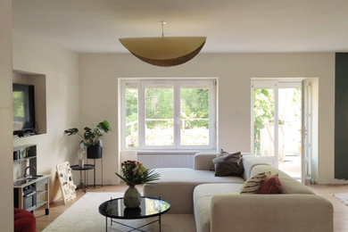Idée de décoration pour une grande salle de séjour design ouverte avec un mur beige, parquet clair, aucune cheminée et un sol marron.