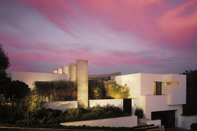 Example of a large minimalist white two-story stucco exterior home design in Los Angeles