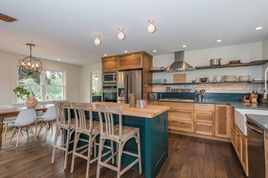 Example of a large farmhouse l-shaped medium tone wood floor and brown floor open concept kitchen design in New York with a farmhouse sink, shaker cabinets, medium tone wood cabinets, quartzite countertops, white backsplash, marble backsplash, stainless steel appliances and an island