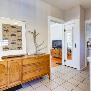 Inredning av en eklektisk stor foajé, med beige väggar, klinkergolv i keramik, en pivotdörr och en vit dörr