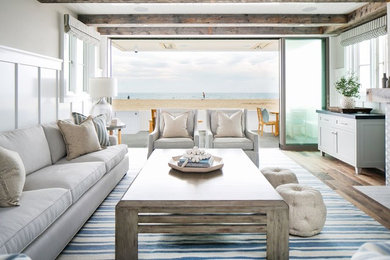 Inspiration for a mid-sized beach style open concept family room in Orange County with white walls, dark hardwood floors, a standard fireplace, a tile fireplace surround, a wall-mounted tv and brown floor.