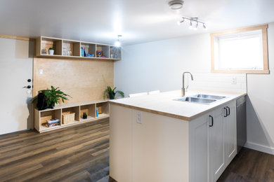 Eat-in kitchen - small modern laminate floor and brown floor eat-in kitchen idea in Other with a double-bowl sink, recessed-panel cabinets, white cabinets, wood countertops, white backsplash, ceramic backsplash, stainless steel appliances and an island