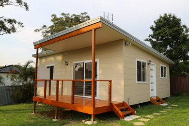 This is an example of a traditional one-storey beige exterior in Central Coast with a flat roof.