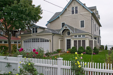 Example of a classic beige wood exterior home design in Bridgeport with a shed roof and a shingle roof
