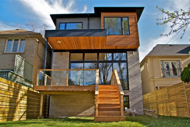 Mid-sized contemporary three-storey multi-coloured house exterior in Toronto with mixed siding.