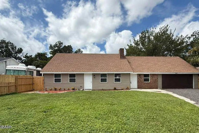 Large beige one-story vinyl exterior home idea in Other with a shingle roof and a brown roof