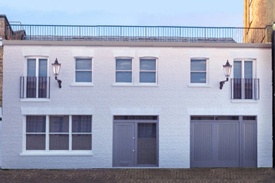 Vierstöckiges Klassisches Reihenhaus mit Backsteinfassade, weißer Fassadenfarbe, Mansardendach, Schindeldach und grauem Dach in London
