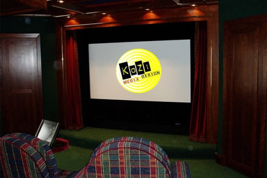 This is an example of a mid-sized traditional enclosed home theatre in Other with carpet and a projector screen.