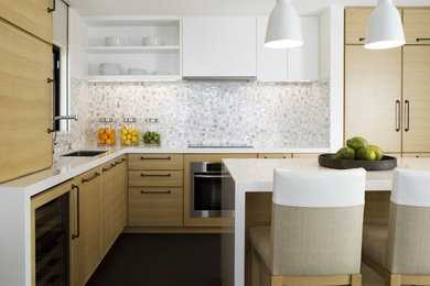 Contemporary kitchen in Hawaii with white splashback, flat-panel cabinets and light wood cabinets.