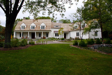 Large traditional two-storey white house exterior in Chicago with wood siding, a gable roof and a shingle roof.