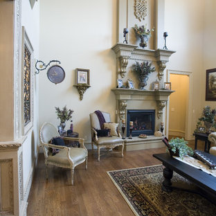 Inspiration for a mediterranean open plan living room in Portland Maine with a home bar, black walls, medium hardwood flooring, a standard fireplace and a wooden fireplace surround.