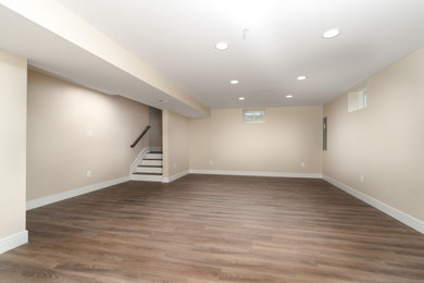 Example of a mid-sized classic underground vinyl floor and brown floor basement design in DC Metro with beige walls