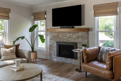 Inspiration for a mid-sized transitional open concept medium tone wood floor and brown floor family room remodel in Chicago with beige walls, a standard fireplace, a stone fireplace and a wall-mounted tv