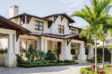 Tropical beige two-story exterior home idea in Miami with a tile roof and a brown roof