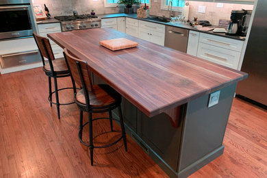Large trendy galley medium tone wood floor eat-in kitchen photo in Chicago with an integrated sink, wood countertops, stainless steel appliances, an island and brown countertops
