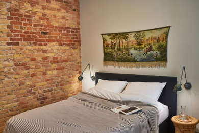 Kleines Nordisches Schlafzimmer im Loft-Style mit grauer Wandfarbe, hellem Holzboden und Ziegelwänden in Berlin