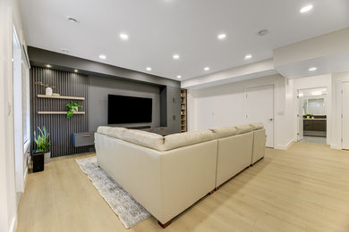 Example of a trendy laminate floor and beige floor basement design in Edmonton with a home theater and white walls