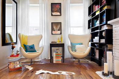 Trendy enclosed medium tone wood floor living room photo in New York with a brick fireplace