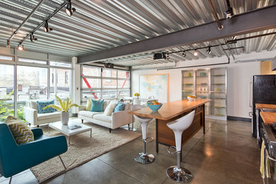 Inspiration for an industrial concrete floor living room remodel in Seattle with white walls, no fireplace and no tv