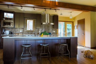 Inspiration for a large modern l-shaped medium tone wood floor open concept kitchen remodel in Calgary with an undermount sink, flat-panel cabinets, dark wood cabinets, quartzite countertops, brown backsplash, glass tile backsplash, stainless steel appliances and an island