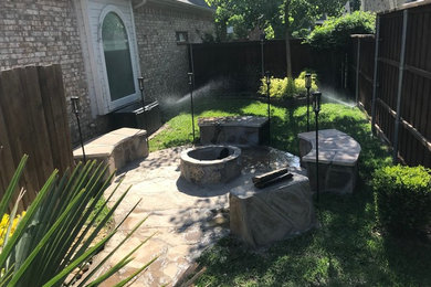 Inspiration for a large traditional backyard partial sun xeriscape in Dallas with a fire feature and natural stone pavers.
