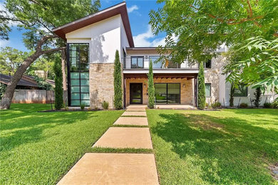 Example of a large trendy white two-story mixed siding house exterior design in Dallas with a shed roof and a metal roof