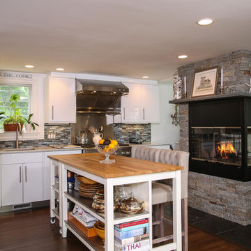 Three sided stone fireplace in this chef's kitchen
