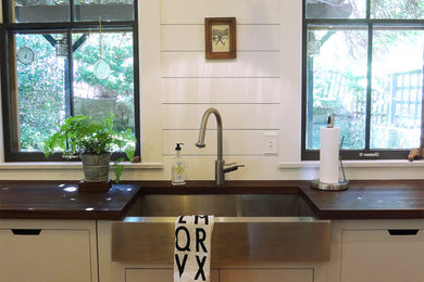 Mid-sized contemporary galley eat-in kitchen in Philadelphia with a farmhouse sink, flat-panel cabinets, white cabinets, wood benchtops and light hardwood floors.