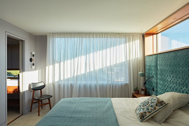 サセックスにある中くらいなミッドセンチュリースタイルのおしゃれな主寝室 (白い壁、カーペット敷き、ベージュの床、パネル壁、アクセントウォール) のレイアウト