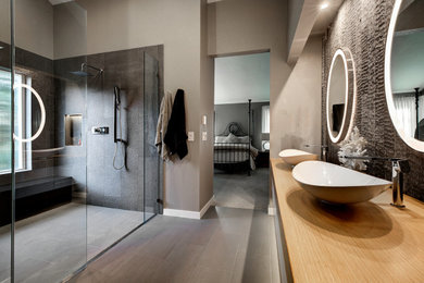 Inspiration för stora moderna en-suite badrum, med släta luckor, skåp i ljust trä, ett fristående badkar, en dusch i en alkov, svart kakel, porslinskakel, klinkergolv i porslin, ett undermonterad handfat, träbänkskiva, grått golv och med dusch som är öppen