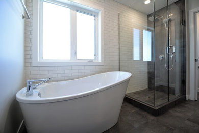 Photo of a mid-sized contemporary master bathroom in Calgary with flat-panel cabinets, dark wood cabinets, a freestanding tub, an open shower, a two-piece toilet, black and white tile, ceramic tile, grey walls, porcelain floors, a drop-in sink, quartzite benchtops, brown floor and an open shower.