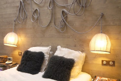 Cette image montre une chambre parentale chalet de taille moyenne avec un mur beige, parquet clair et un sol blanc.