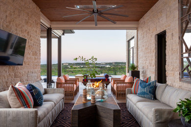 Example of a mid-sized transitional backyard patio design in Austin with a fire pit and a roof extension