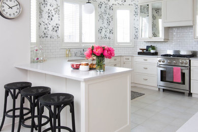 Mid-sized transitional u-shaped porcelain tile kitchen photo in Toronto with an undermount sink, shaker cabinets, white cabinets, quartz countertops, white backsplash, subway tile backsplash and stainless steel appliances