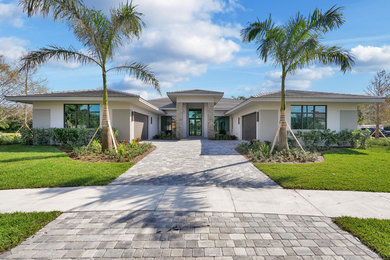Large transitional beige one-story stucco house exterior idea in Miami with a hip roof and a shingle roof