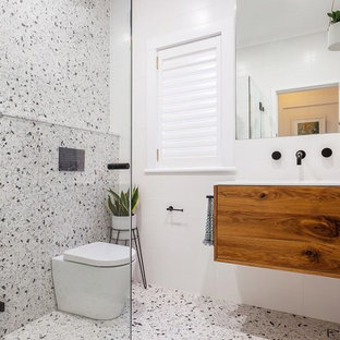 Ispirazione per una stanza da bagno con doccia moderna di medie dimensioni con consolle stile comò, ante in legno bruno, zona vasca/doccia separata, WC sospeso, pistrelle in bianco e nero, piastrelle in pietra, pareti bianche, pavimento alla veneziana, lavabo integrato, top in quarzo composito, pavimento multicolore, porta doccia a battente e top bianco