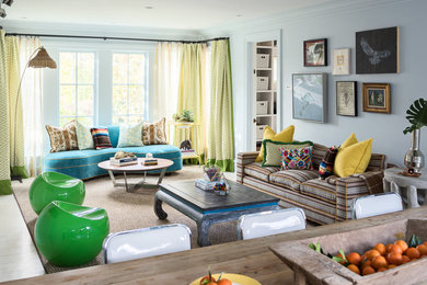 Design ideas for a mid-sized eclectic open concept family room in New York with blue walls, light hardwood floors, no fireplace, a built-in media wall and grey floor.