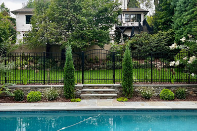 Diseño de piscina alargada mediterránea grande rectangular en patio trasero con paisajismo de piscina y adoquines de piedra natural