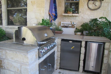 Example of a large trendy backyard stone patio kitchen design in Austin
