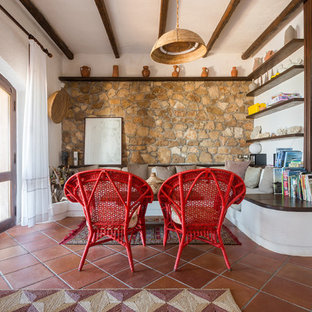 Mediterranes Wohnzimmer mit brauner Wandfarbe, Terrakottaboden und rotem Boden in Sonstige