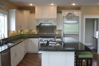 Example of a classic medium tone wood floor kitchen design in Other with an undermount sink, raised-panel cabinets, white cabinets, granite countertops, mosaic tile backsplash, stainless steel appliances and an island
