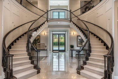 Large modern carpeted spiral wood railing staircase in Other with carpeted risers, panelled walls and feature lighting.