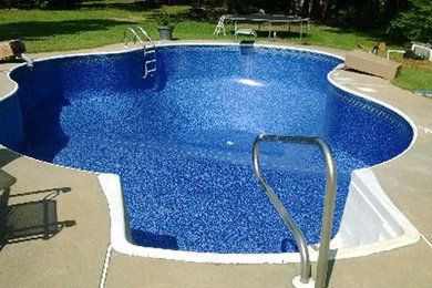 Inspiration for a mid-sized transitional backyard concrete and custom-shaped pool remodel in Other