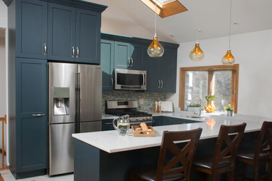 Mid-sized transitional u-shaped porcelain tile and white floor open concept kitchen photo in Chicago with an undermount sink, shaker cabinets, blue cabinets, quartz countertops, multicolored backsplash, glass tile backsplash, stainless steel appliances and a peninsula
