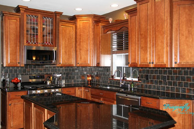 Example of a mid-sized mountain style u-shaped medium tone wood floor kitchen design in Philadelphia with an undermount sink, raised-panel cabinets, medium tone wood cabinets, granite countertops, metallic backsplash, porcelain backsplash, stainless steel appliances and an island