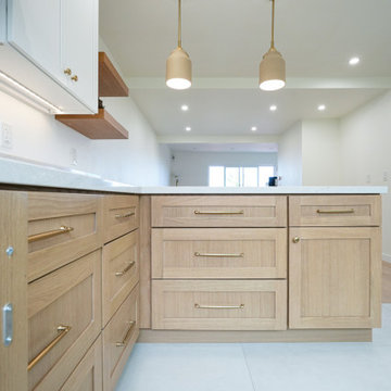 Modern White and Natural Oak Kitchen with Brass Hardware and Quartz Backsplash