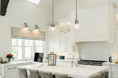 Open concept kitchen - large contemporary dark wood floor and brown floor open concept kitchen idea in Jacksonville with a farmhouse sink, shaker cabinets, white cabinets, marble countertops, white backsplash, paneled appliances, an island and white countertops