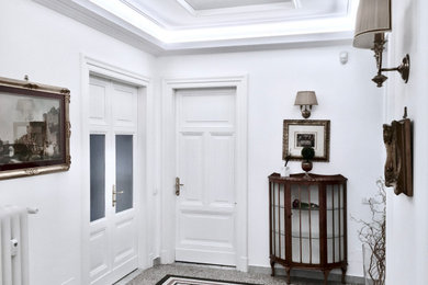 Esempio di un ingresso tradizionale con pareti bianche e pavimento alla veneziana
