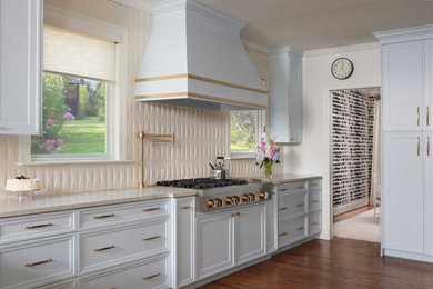 Inspiration for a mid-sized transitional l-shaped medium tone wood floor and brown floor enclosed kitchen remodel in Dallas with an undermount sink, recessed-panel cabinets, blue cabinets, quartz countertops, beige backsplash, porcelain backsplash, paneled appliances, a peninsula and beige countertops